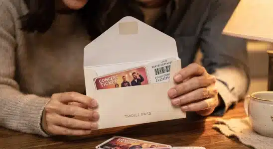 Couple opening an experience gift envelope with tickets and vouchers