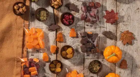 A spread of healthy Halloween candy swaps including dark chocolate and organic fruit snacks.