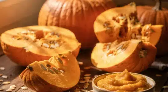 Fresh sliced pumpkin and pumpkin seeds on a wooden kitchen table displaying pumpkin nutrition benefits.