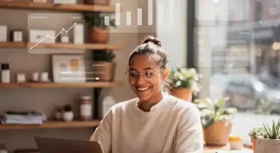 Small business owner using modern AI tools on a laptop to manage daily shop operations.