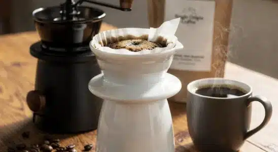A collection of specialty coffee gear and fresh roasted coffee beans on a wooden counter.