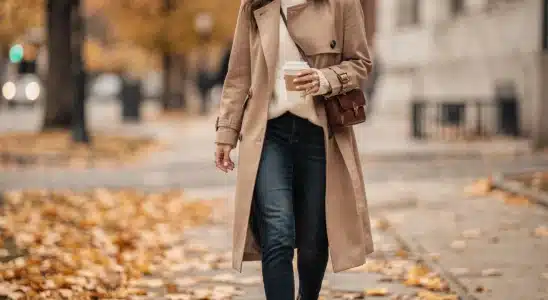 Woman wearing a stylish camel fall jacket walking on an autumn sidewalk
